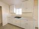 Functional kitchen featuring white cabinetry, tile flooring, and ample counter space at 1912 W Carey Ave, North Las Vegas, NV 89032