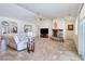 Bright living room with a white leather couch, ceiling fan, stone fireplace, and tile and wood flooring at 1981 Labrador St, Pahrump, NV 89048