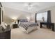 Bright bedroom featuring plush carpeting, a ceiling fan, and a large window allowing ample natural light at 2401 Windjammer Way, Las Vegas, NV 89107