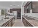 Well-equipped kitchen with a stainless-steel refrigerator, oven, gas cooktop, and granite countertops at 2494 Veronella St, Henderson, NV 89044