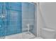 Shower featuring blue, vertically stacked tiles and a glass enclosure in a modern bathroom at 2494 Veronella St, Henderson, NV 89044