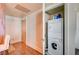 Hallway featuring hardwood floors, a chair, entry door and a stacked washer and dryer at 2700 Las Vegas Blvd # 4109, Las Vegas, NV 89109
