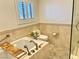 Luxurious bathroom showcasing a soaking tub, elegant tile work, and plantation shutters at 3999 Delos Dr, Las Vegas, NV 89103