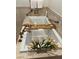 Soaking tub with elegant bronze fixtures, bamboo tray, and a vase of beautiful yellow flowers at 3999 Delos Dr, Las Vegas, NV 89103