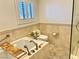 Elegant bathtub with decorative tile, brass hardware, and natural light at 3999 Delos Dr, Las Vegas, NV 89103