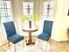 Cozy dining nook with round table, blue chairs, and natural light from shuttered windows at 3999 Delos Dr, Las Vegas, NV 89103