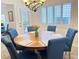 Dining room boasts wood table with six blue chairs and bright natural light at 3999 Delos Dr, Las Vegas, NV 89103