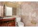 Bathroom featuring decorative marble walls, a wood vanity, and a large mirror, exuding classic elegance at 4245 N Campbell Rd, Las Vegas, NV 89129