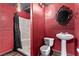 Unique bathroom design with vibrant red walls, black framed mirror, and shower, offering a bold, modern aesthetic at 4245 N Campbell Rd, Las Vegas, NV 89129