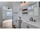 Dual sink bathroom with wood floors, modern fixtures, mirrors, and floating shelves, combining functionality with contemporary design at 435 Regal Robin Way, North Las Vegas, NV 89084