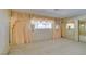 Cozy bedroom with carpet flooring, large windows with curtains, and mirrored closet doors at 4530 W Maulding Ave, Las Vegas, NV 89139