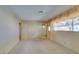 Bright bedroom featuring carpet flooring, large window with curtains, and bathroom access at 4530 W Maulding Ave, Las Vegas, NV 89139