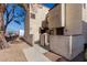 Two-story stucco exterior of a townhouse with a fenced front patio and mature tree at 5015 Spencer St # C, Las Vegas, NV 89119