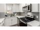 Updated kitchen featuring white cabinets, granite countertops, and modern appliances at 5015 Spencer St # C, Las Vegas, NV 89119