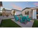 Beautiful backyard with lush green grass, Adirondack chairs and ambient string lighting at 5865 Alice Landing Ct, Las Vegas, NV 89149