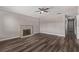 Bright and airy living room featuring hardwood floors and a cozy brick fireplace, with a ceiling fan at 6412 Miragrande Dr, Las Vegas, NV 89108