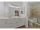 Bright bathroom with dual sink vanity, large mirror, and tiled shower at 6704 Indian Chief Dr # 101, Las Vegas, NV 89130