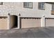 Three-car garage featuring a neutral door color and white textured exterior at 6704 Indian Chief Dr # 101, Las Vegas, NV 89130