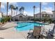 Community pool with lounge chairs and palm trees at 6704 Indian Chief Dr # 101, Las Vegas, NV 89130