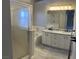 Bathroom featuring double sinks, granite countertops, a soaking tub and a glass-enclosed shower at 70 Moonlight Village Ln, Henderson, NV 89012