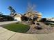 Charming single-story home featuring desert landscaping, green grass, and a two-car garage at 70 Moonlight Village Ln, Henderson, NV 89012