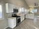 Bright kitchen boasts white cabinets, stainless steel appliances, and granite countertops at 70 Moonlight Village Ln, Henderson, NV 89012