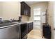 Laundry room with appliances, storage, and convenient hanging rack at 701 Dowland St, Henderson, NV 89011