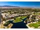 Stunning aerial view showcases the community lake, golf course, and the homes against a mountain backdrop at 7231 Indian Creek Ln # 204, Las Vegas, NV 89149