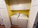 A functional laundry area with a washer, dryer, and ample overhead cabinet space at 7231 Indian Creek Ln # 204, Las Vegas, NV 89149