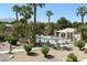 A fenced community pool with a covered poolside area is surrounded by palm trees and lush landscaping at 7231 Indian Creek Ln # 204, Las Vegas, NV 89149