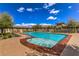 Sparkling community pool featuring shallow end access, lounge chairs, and well-maintained surrounding landscaping at 7735 Sugarloaf Peak St, Las Vegas, NV 89166