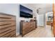 Modern main bedroom featuring wood flooring, stylish dressers, and a large television at 8220 Flowing Rapids Ct, Las Vegas, NV 89131