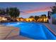 In-ground pool, patio furniture, lush backyard landscaping, and colorful sunset view at 8220 Flowing Rapids Ct, Las Vegas, NV 89131