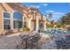 Charming backyard featuring a private pool, covered patio, lush landscaping, and elegant outdoor dining space at 8225 Taos Paseo Ave, Las Vegas, NV 89128