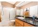 Well-lit bathroom with a granite countertop, shower over tub and modern fixtures at 8225 Taos Paseo Ave, Las Vegas, NV 89128