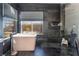 Luxurious bathroom featuring soaking tub, shower with dark tiling, and bright window at 8225 Taos Paseo Ave, Las Vegas, NV 89128