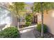 Inviting front entrance with a walkway framed by lush landscaping and ornamental trees at 8225 Taos Paseo Ave, Las Vegas, NV 89128