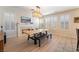 Open living room with fireplace, plantation shutters, and modern light fixture over dining table at 8225 Taos Paseo Ave, Las Vegas, NV 89128