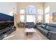 Bright living room featuring hardwood floors, two-story ceilings, and plenty of natural light at 8225 Taos Paseo Ave, Las Vegas, NV 89128