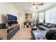 Spacious living room with a large leather couch and a ceiling fan at 8225 Taos Paseo Ave, Las Vegas, NV 89128