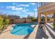 Private backyard pool and outdoor dining area with desert landscaping creating an ideal setting for relaxation and entertaining at 8225 Taos Paseo Ave, Las Vegas, NV 89128