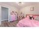 A bedroom with a pink bed, charming decorations, and light gray wood-look floors at 8348 Brittany Harbor Dr, Las Vegas, NV 89128