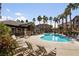 Community pool with palm trees and lounge chairs on a sunny day at 8805 Jeffreys St # 2002, Las Vegas, NV 89123