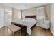 Bright bedroom featuring a wood frame bed, bench, chair, and neutral decor at 9005 Picket Fence Ave, Las Vegas, NV 89143