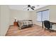 Bedroom featuring wood-look floors, a desk, and large window with blinds at 9563 Grapeland Ave, Las Vegas, NV 89148