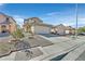 Tan two-story home featuring attached garage, landscaped yard and desert landscaping under bright blue skies at 9563 Grapeland Ave, Las Vegas, NV 89148