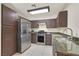 Kitchen featuring stainless steel appliances, dark cabinets, granite countertops and tile floors at 9563 Grapeland Ave, Las Vegas, NV 89148