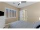 Inviting bedroom featuring a bed, dresser, ceiling fan and an ensuite bathroom at 11473 Glowing Sunset Ln, Las Vegas, NV 89135