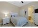 Cozy bedroom showcases a bed, nightstand, dresser, ceiling fan and ensuite bathroom at 11473 Glowing Sunset Ln, Las Vegas, NV 89135