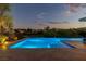 Dusk view of private pool with inviting lights and landscaping at 11473 Glowing Sunset Ln, Las Vegas, NV 89135
